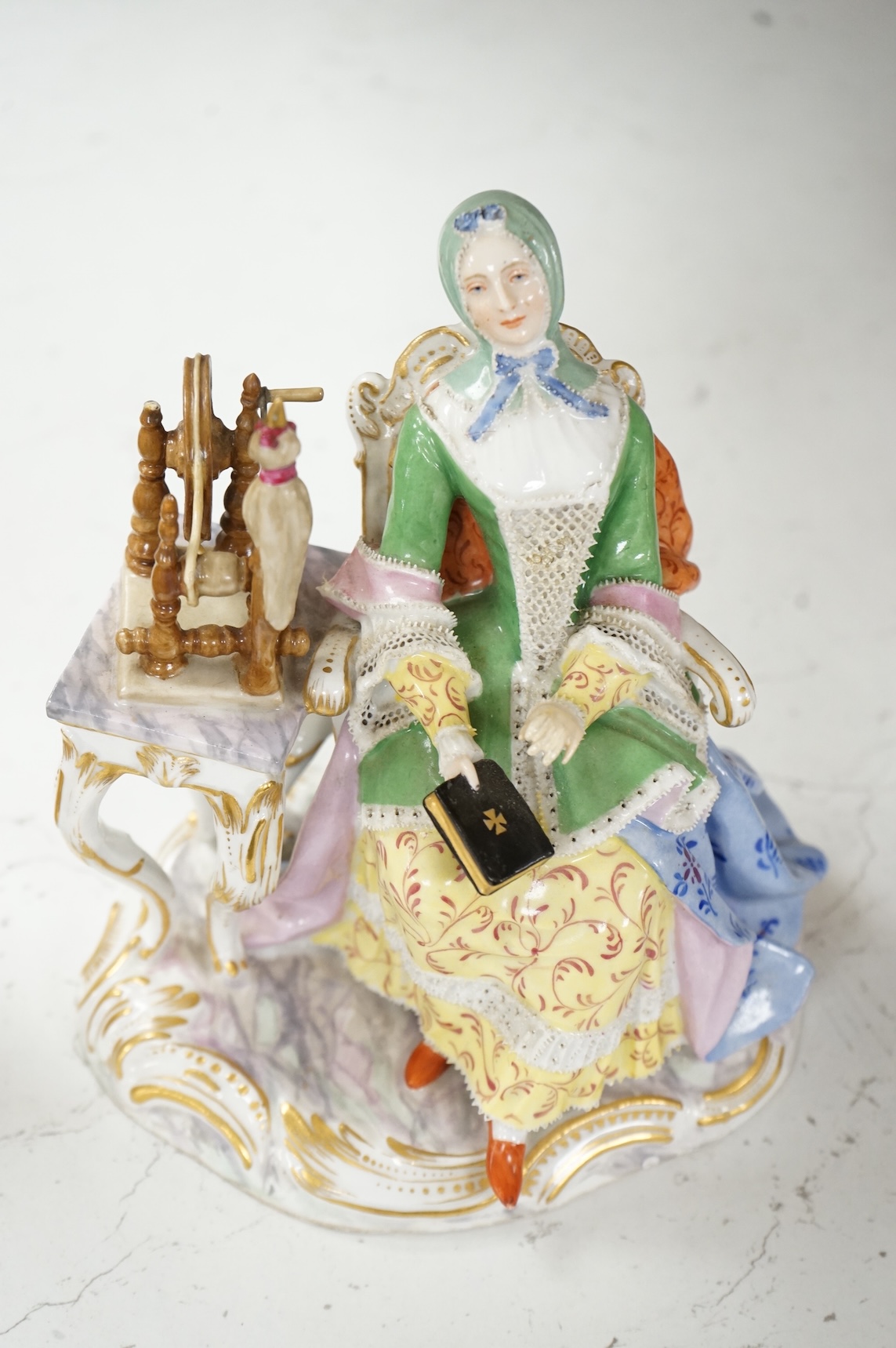 A Meissen style figure of a seated lady at her spinning wheel, 15.5cm high.